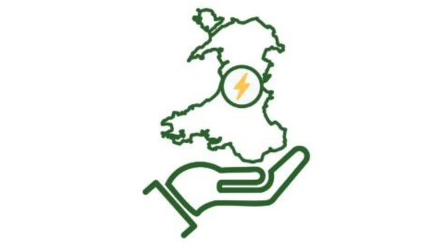 A hand holding a map of wales which contains a lightning bolt